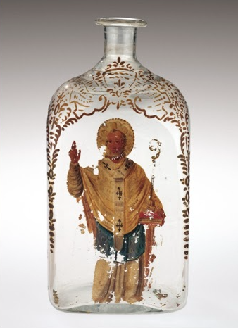 Glass bottle with gold filligree around the top and an image of Sain Nicholas painted on the front. The painting is damaged.